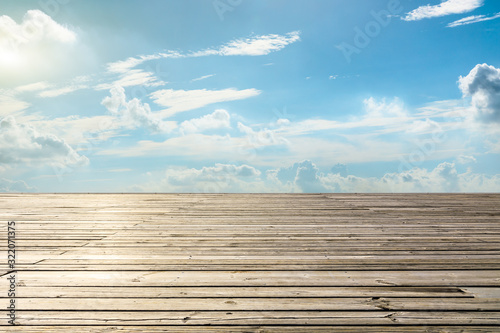 Empty wooden board square and blue sky with white clouds