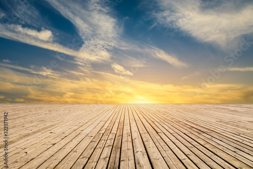 Empty wooden board square and sunset yellow sky