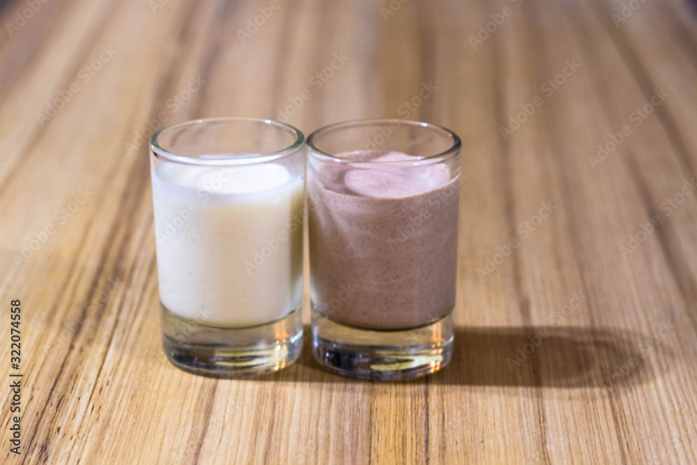 cream and chocolate dessert made of sour cream in glasses on the background of a bamboo table top close-up cream and chocolate dessert made of sour cream in glasses on the background of a bamboo table top close-up