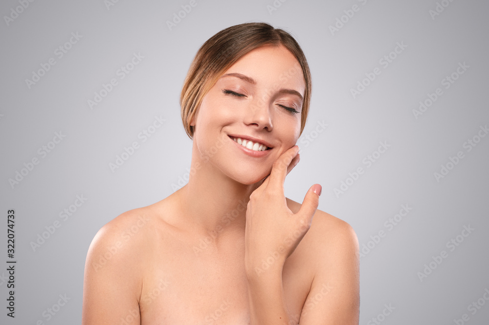 Delighted young model touching cheek skin Delighted young model touching cheek skin