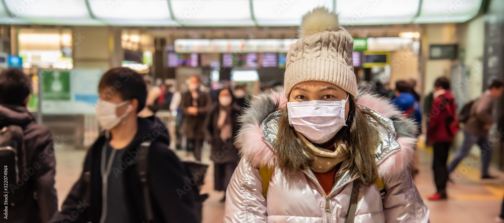 Traveler woman wears medical mask to protect against coronavirus on public transport station.