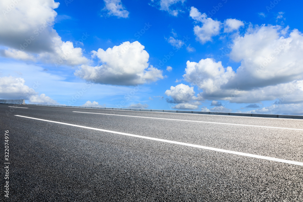 Empty asphalt road and blue sky with white clouds in summer