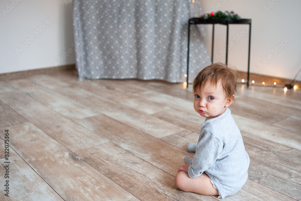 Little cute one year old girl sitting on floor at home. Little cute one year old girl sitting on floor at home.