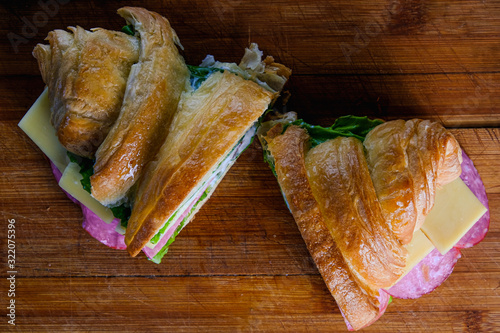 croissant with ham and cheese isolated on a wooden background