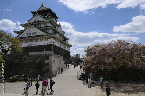 Osaka castle with people and park before blue sky, Japanese sight in Osaka, Japan
