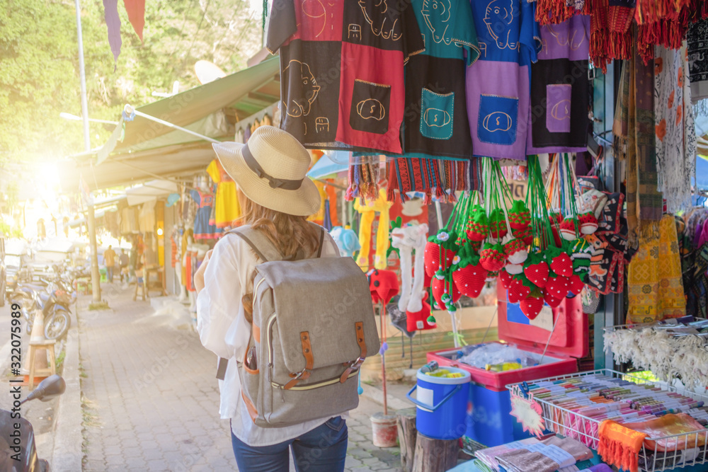 Naklejka premium Smiling woman traveler in doi suthep temple chiangmai landmark in thailand with backpack on holiday, relaxation concept, travel concept
