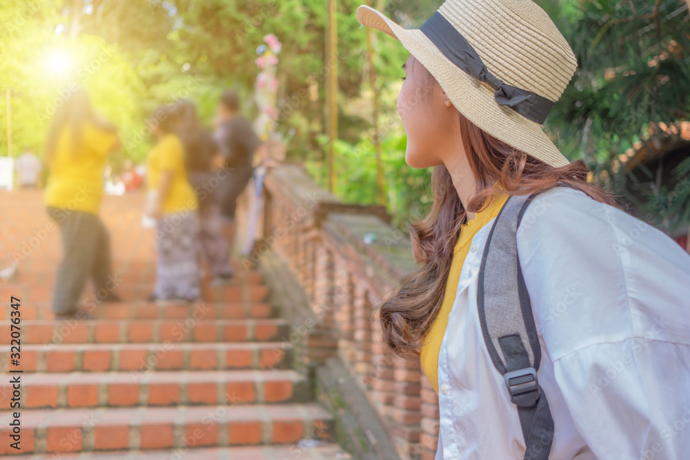 Smiling woman traveler in doi suthep temple chiangmai landmark in thailand with backpack on holiday, relaxation concept, travel concept