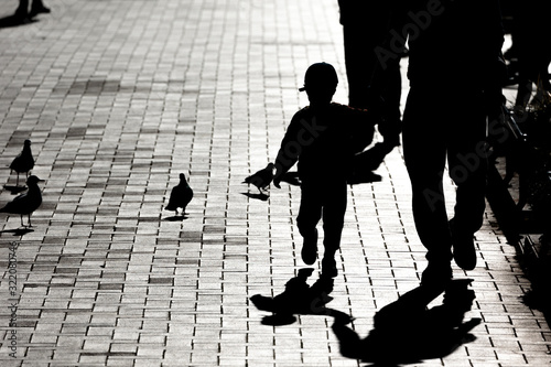 休日の昼下がりの公園で逆光に浮かぶシルエット、神奈川県横浜市山下公園・日本