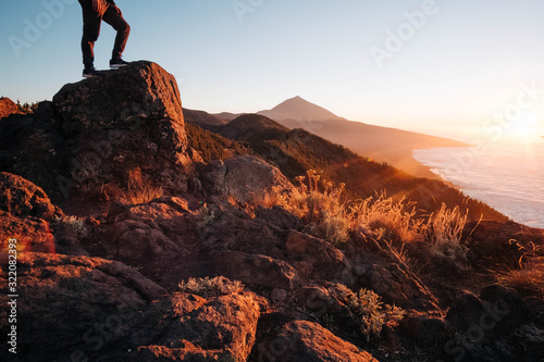 tourist on top of a rock in a volcanic landscape