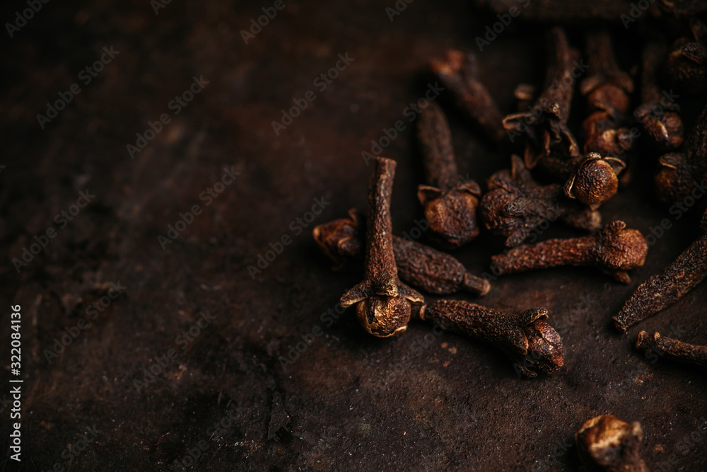 Dry cloves spices on the dark rustic background. Selective focus. shallow depth of field. Dry cloves spices on the dark rustic background. Selective focus. shallow depth of field.