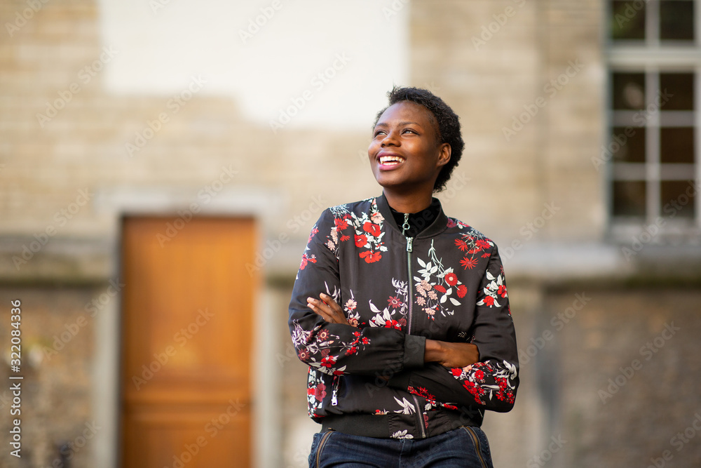 Horizontal happy african woman with arms crossed in city