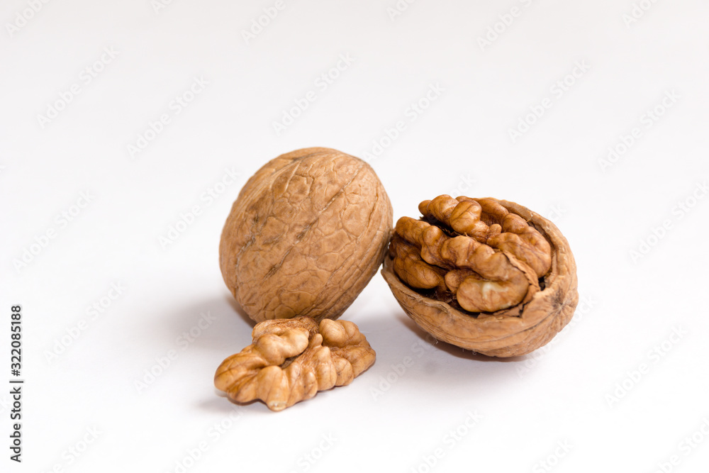 Delicious whole and broken walnuts, isolated on white background Delicious whole and broken walnuts, isolated on white background
