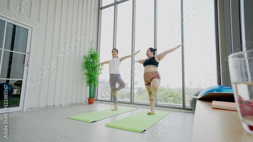 Asian fat woman Training to lose weight in the gym. With a beautiful female trainer Helping to teach in various exercise positions intentionally