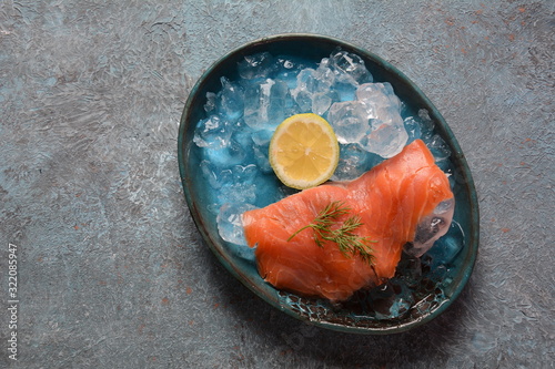Smoked salmon on a plate with lemon on the gray background