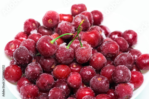 frozen fresh cherries on a white background. an ingredient for smoothies and smoothies. ice crystals on the berry. vertical photo. close up.