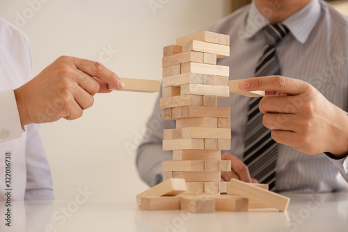 Image of hand holding blocks wood game to growing up of business. Risk of management and strategy plan