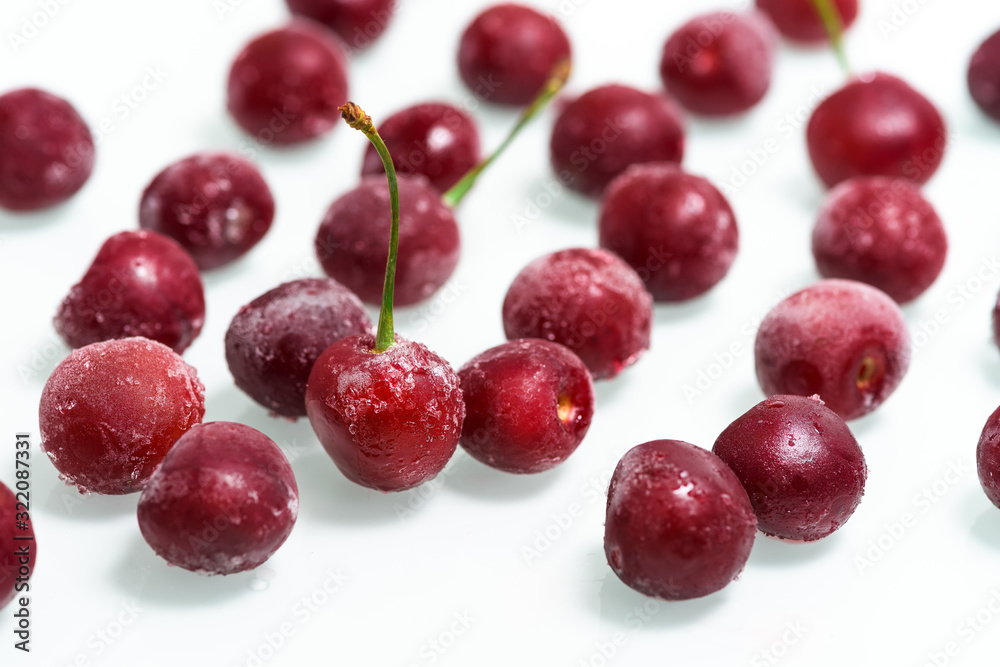 group of frozen cherries on a white background . the view from the top. ice crystals on the berry. vertical photo. close up. group of frozen cherries on a white background . the view from the top. ice crystals on the berry. vertical photo. close up.