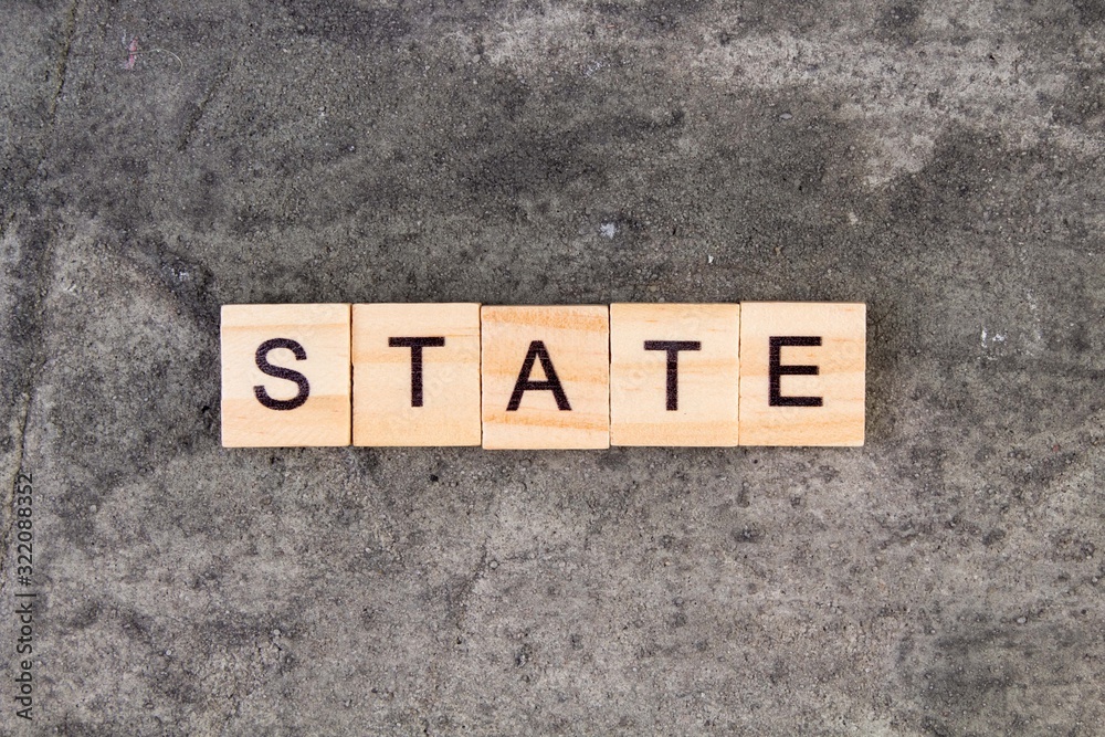 States word written on wood block, on gray concrete background. Top view. States word written on wood block, on gray concrete background. Top view.