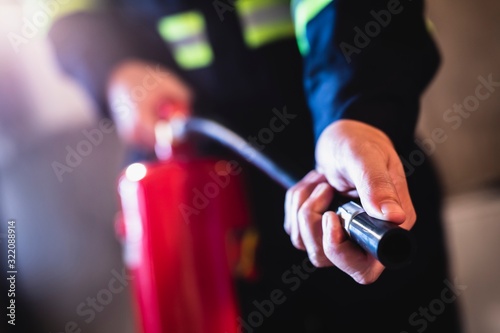 Concept man using fire extinguisher fighting fire closeup photo