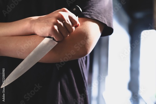 image of robber with knife about to commit a homicide
