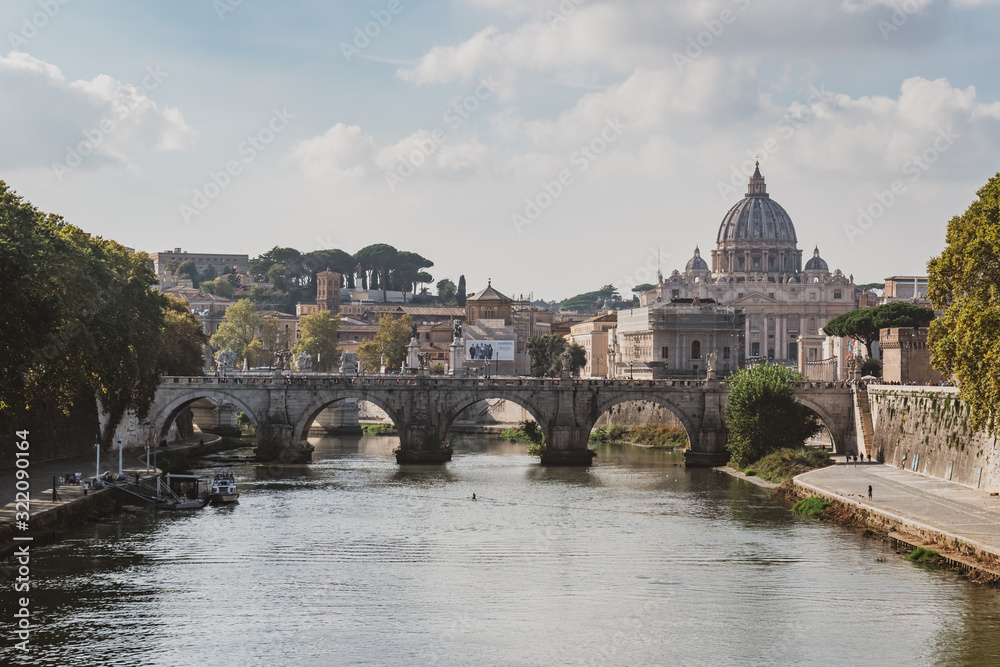 St. Peter's cathedral over bridge and Tiber river water at autumn day Rome