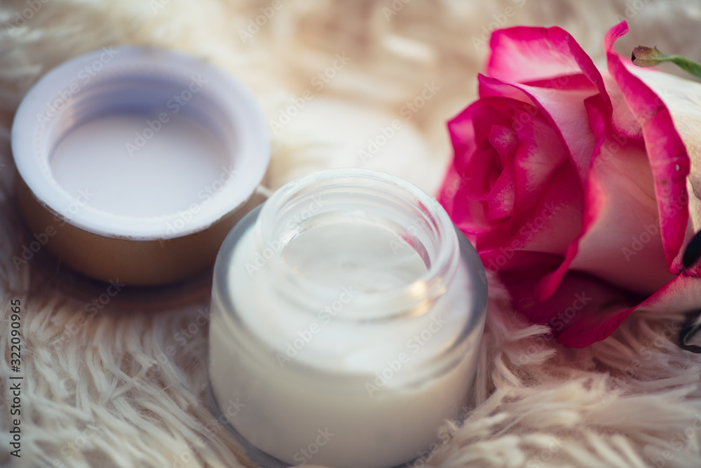 Skincare concept. cream in a glass jar with an open lid and a rose Skincare concept. cream in a glass jar with an open lid and a rose