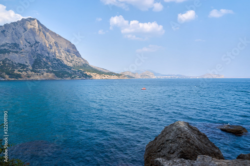 Obraz na płótnie View of the Green Bay in the village of New World, coastal cliffs and a ridge of mountains on the horizon. View of Mount Falcon. Black Sea coast, Sudak region, Republic of Crimea w salonie