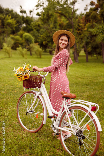 Cheerful woman with retro bicycle in park