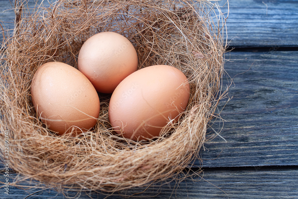 Macro shoot of brown eggs at hay nest in chicken farm Macro shoot of brown eggs at hay nest in chicken farm