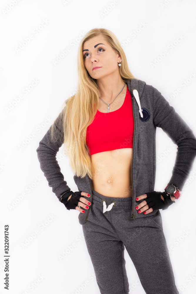  slender woman in a tracksuit is posing on a white background