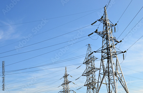 Electricity concept, high voltage power lines. High voltage electric transmission pylon silhouetted tower. Wire electrical energy