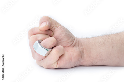 The human hand on the ring finger is wearing a nut like a wedding ring. Close-up. Separate on a white background