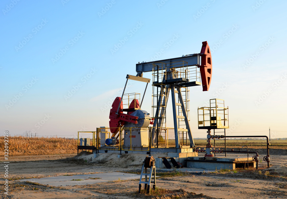Oil drilling derricks at desert oilfield for fossil fuels output and crude oil production from the ground. Oil drill rig and pump jack. Oil drilling derricks at desert oilfield for fossil fuels output and crude oil production from the ground. Oil drill rig and pump jack.