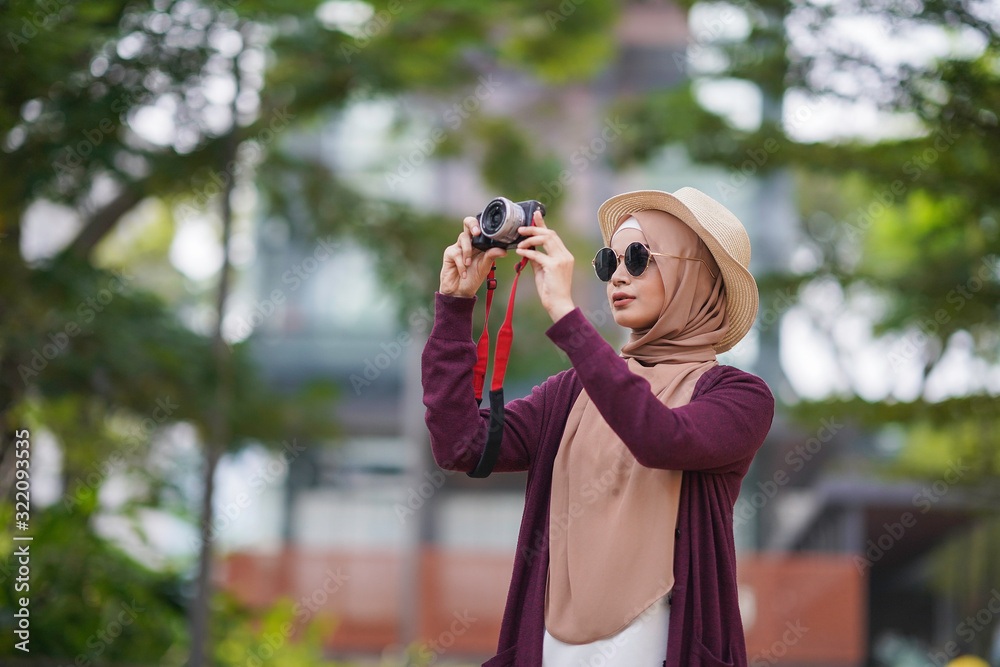 Portrait of beautiful young solo Muslim traveler exploring the city