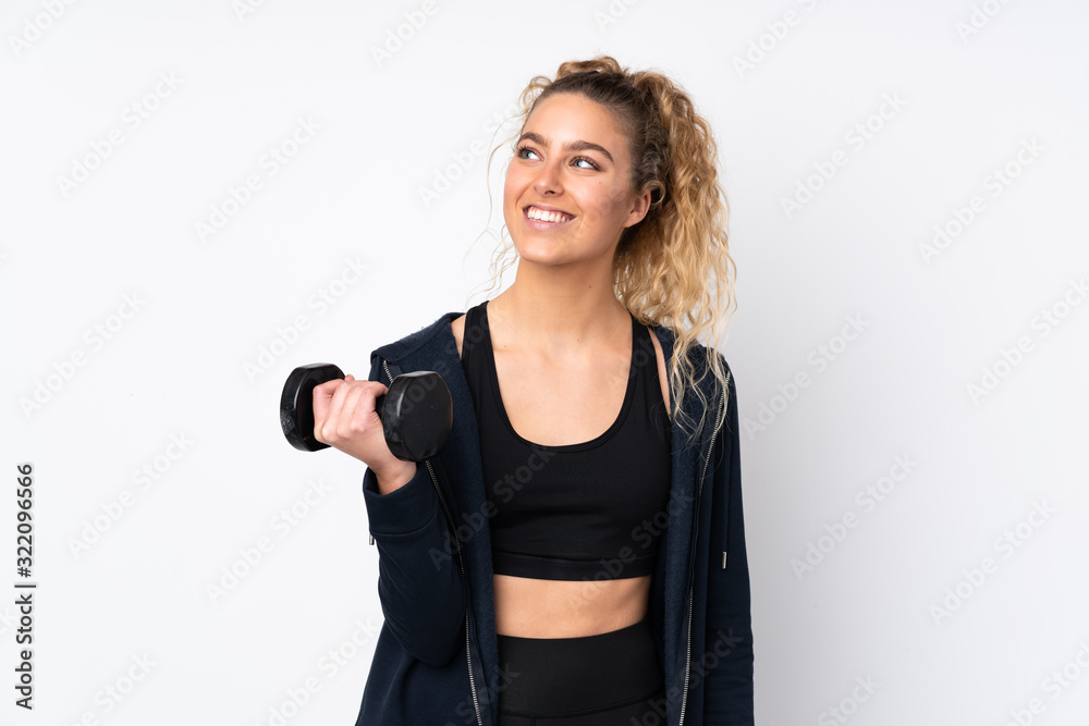 Young sport woman making weightlifting isolated on white background looking up while smiling