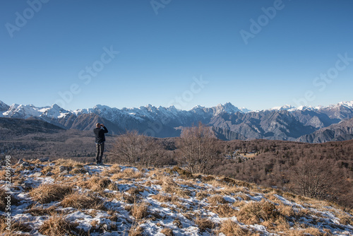 Quadro em tela Hiker looking through binoculars, searching the horizon for his path