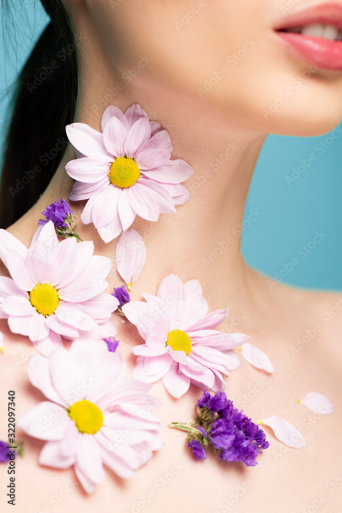 cropped view of young woman with flowers on neck isolated on blue cropped view of young woman with flowers on neck isolated on blue