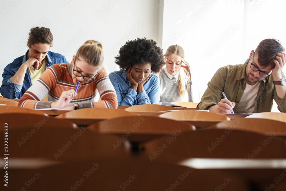 Group of university students taking a test in a classroom.Educational concept.