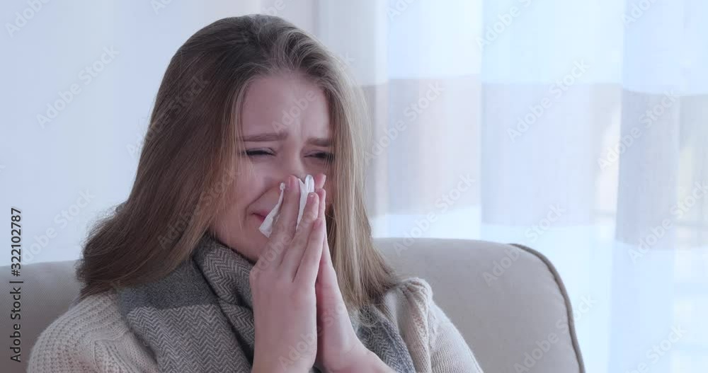 Young woman suffering from cold on sofa at home Young woman suffering from cold on sofa at home