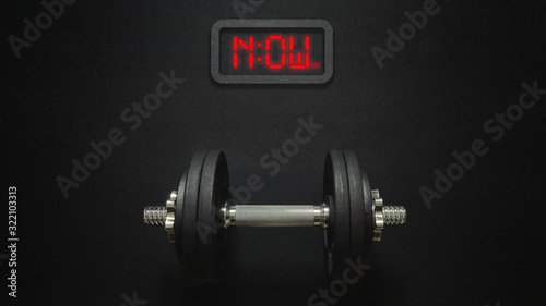 Flat lay of dumbbell with digital clock now it's the time for workout concept