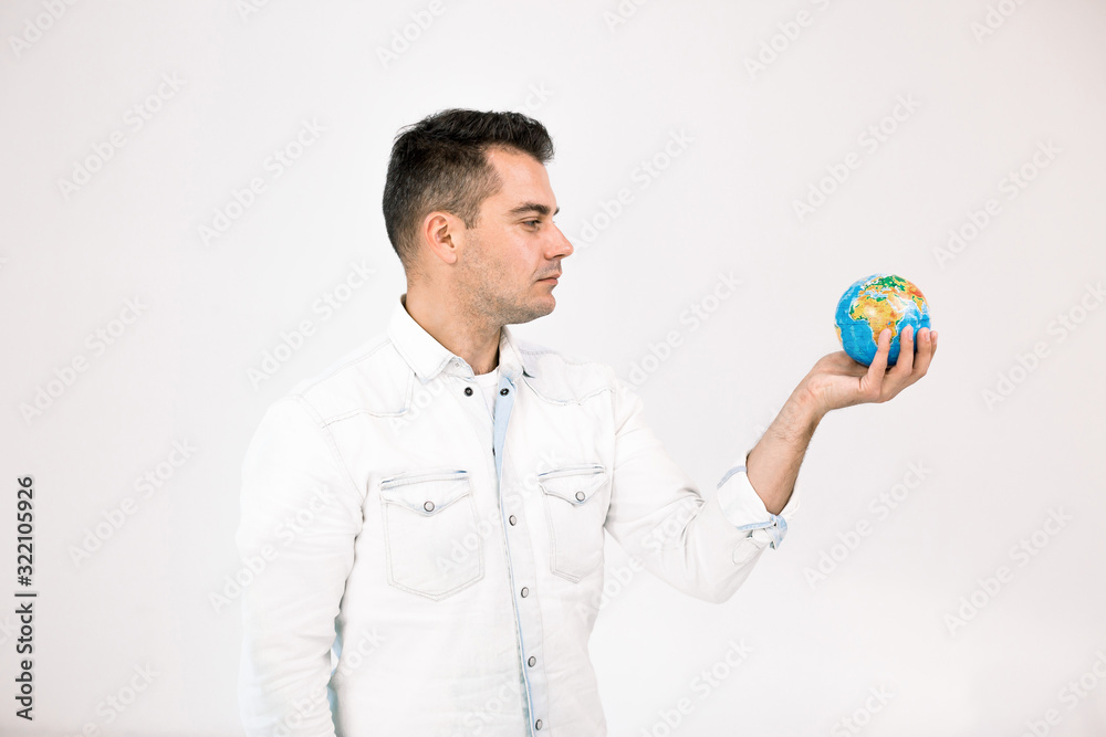 Side half-lengh portrait of handsome caucasian man in white casual shirt holding the Earth globe in his hands, isolated on white. Earth day, ecology concept Side half-lengh portrait of handsome caucasian man in white casual shirt holding the Earth globe in his hands, isolated on white. Earth day, ecology concept