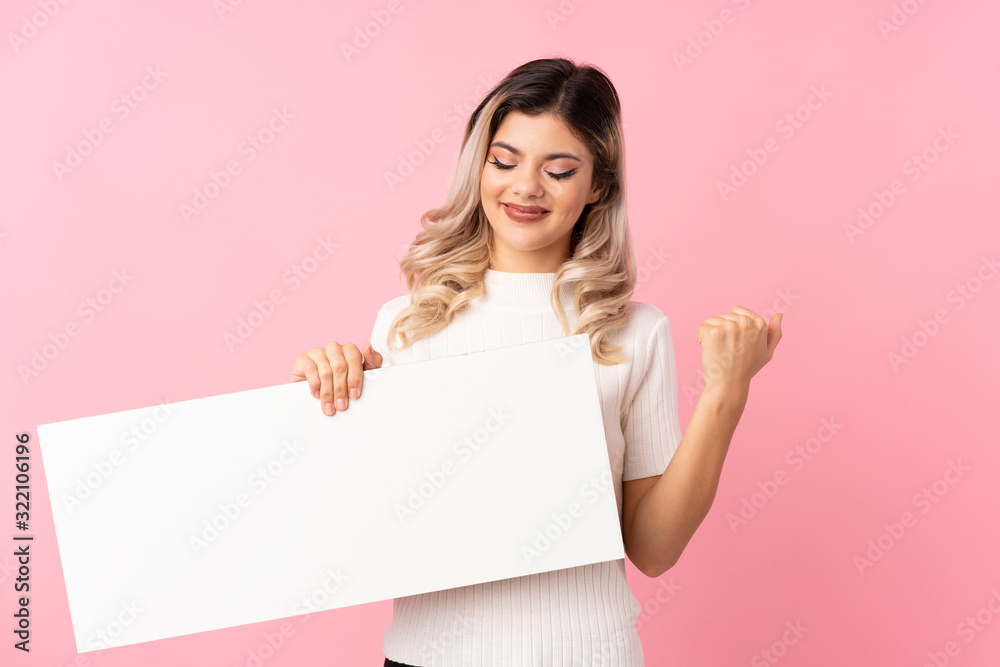 Teenager girl over isolated pink background holding an empty white placard for insert a concept Teenager girl over isolated pink background holding an empty white placard for insert a concept