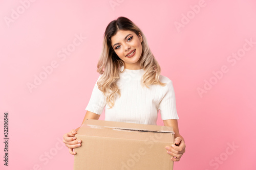 Teenager girl over isolated pink background holding a box to move it to another site