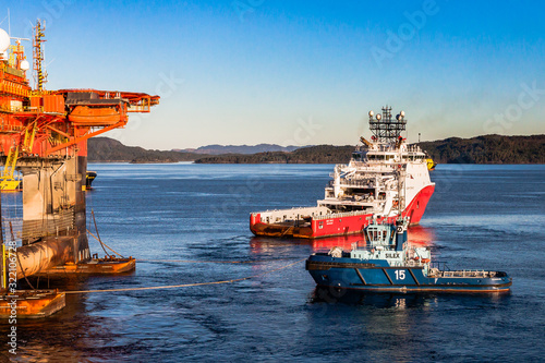 BERGEN, NORWAY - 2014 OCTOBER 16. Offshore vessel Siem Topaz and tugboat Silex under anchor handling operation alongside the semi-submersible drilling rig West Alpha photo