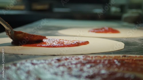 Close up view of a man chef cooking italian pizza. The process of making pizza at table in bakery. Fresh dough on kitchen table
