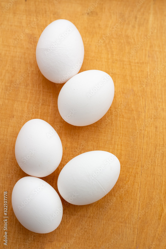 five white eggs lie on a wooden board five white eggs lie on a wooden board