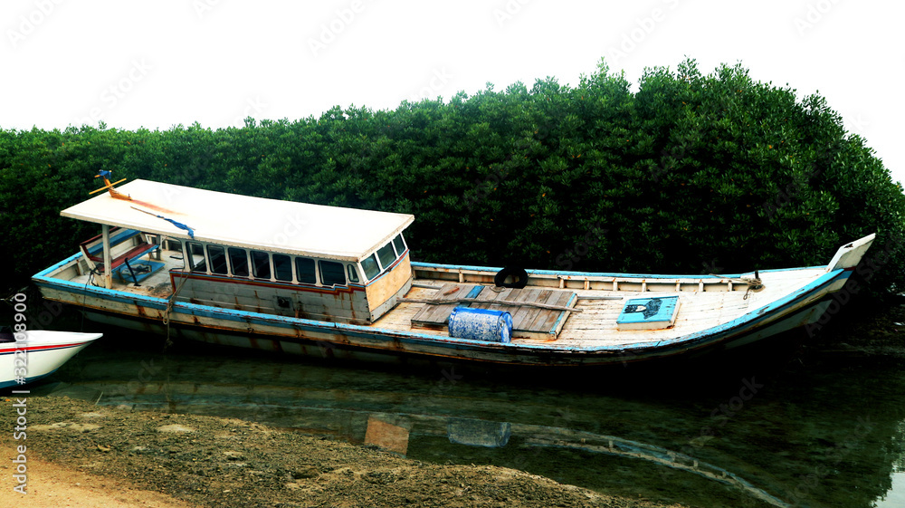 A typical island boat is moored on the coast of A typical island boat is moored on the coast of