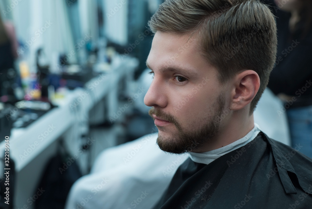 close up portrait of a young bearded guy sitting at the hairdresser while barbershop close up portrait of a young bearded guy sitting at the hairdresser while barbershop