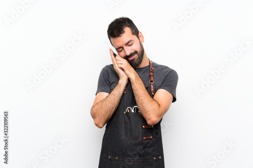 Barber man in an apron making sleep gesture in dorable expression