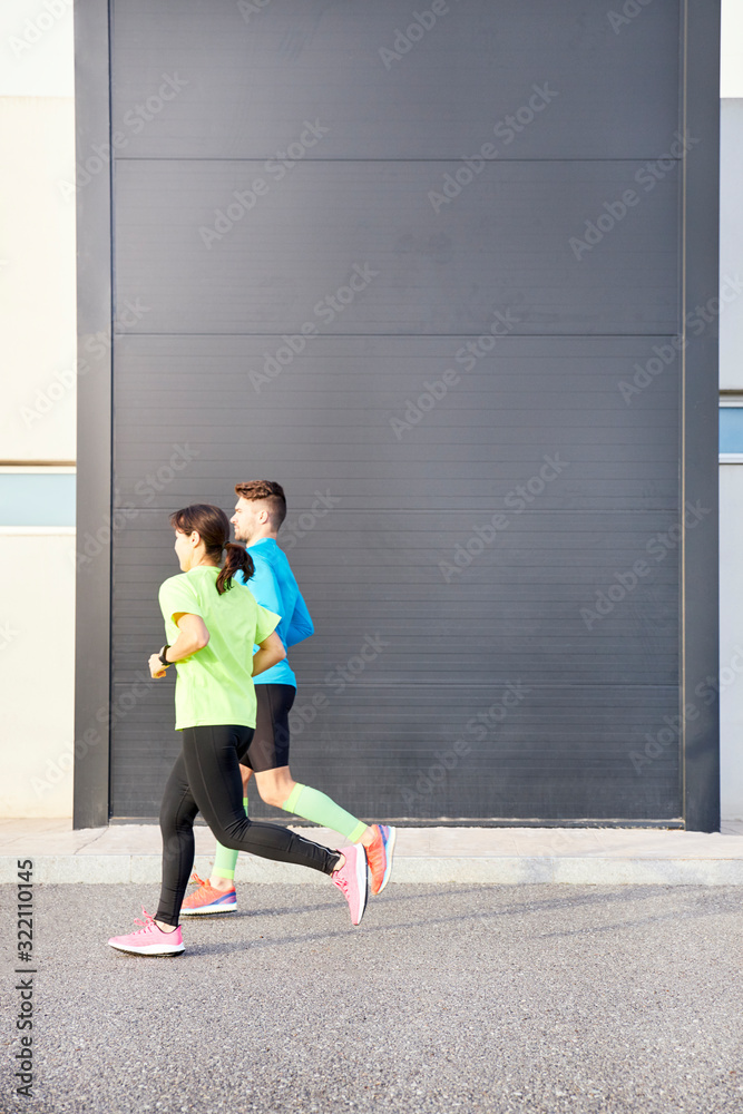 couple of runners running with a modern building in the background couple of runners running with a modern building in the background